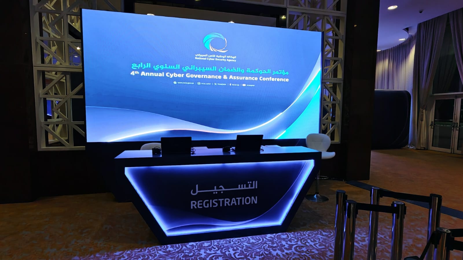 Illuminated registration desk beneath an LED screen