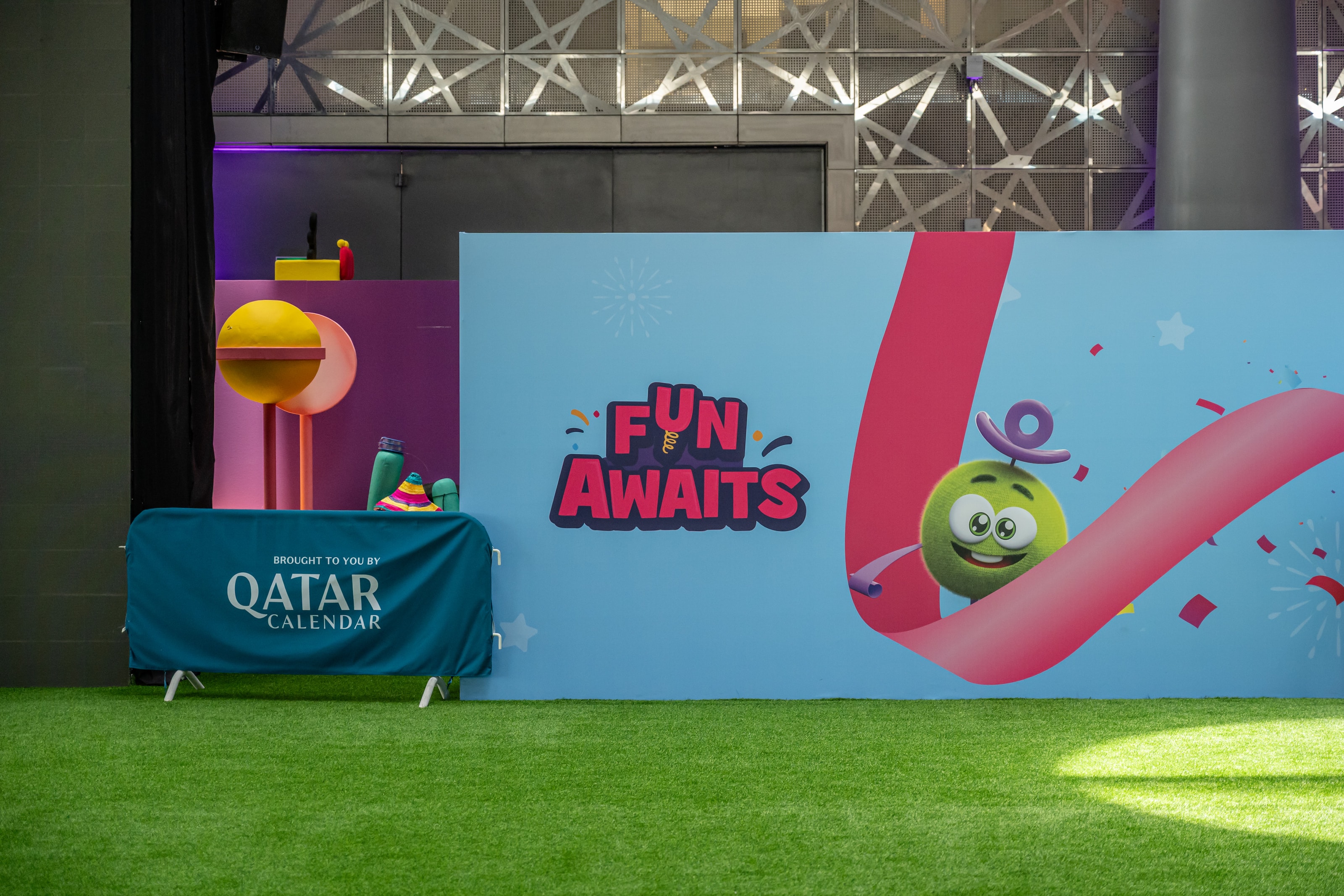 “Fun awaits” wall beside the stage area