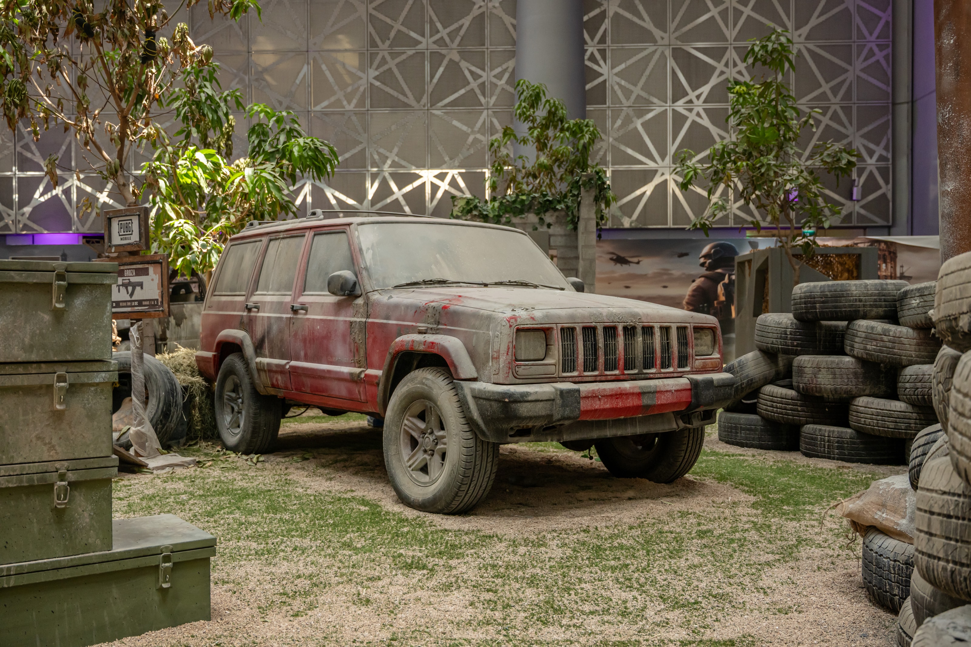 Dust-covered jeep among tyres and crates