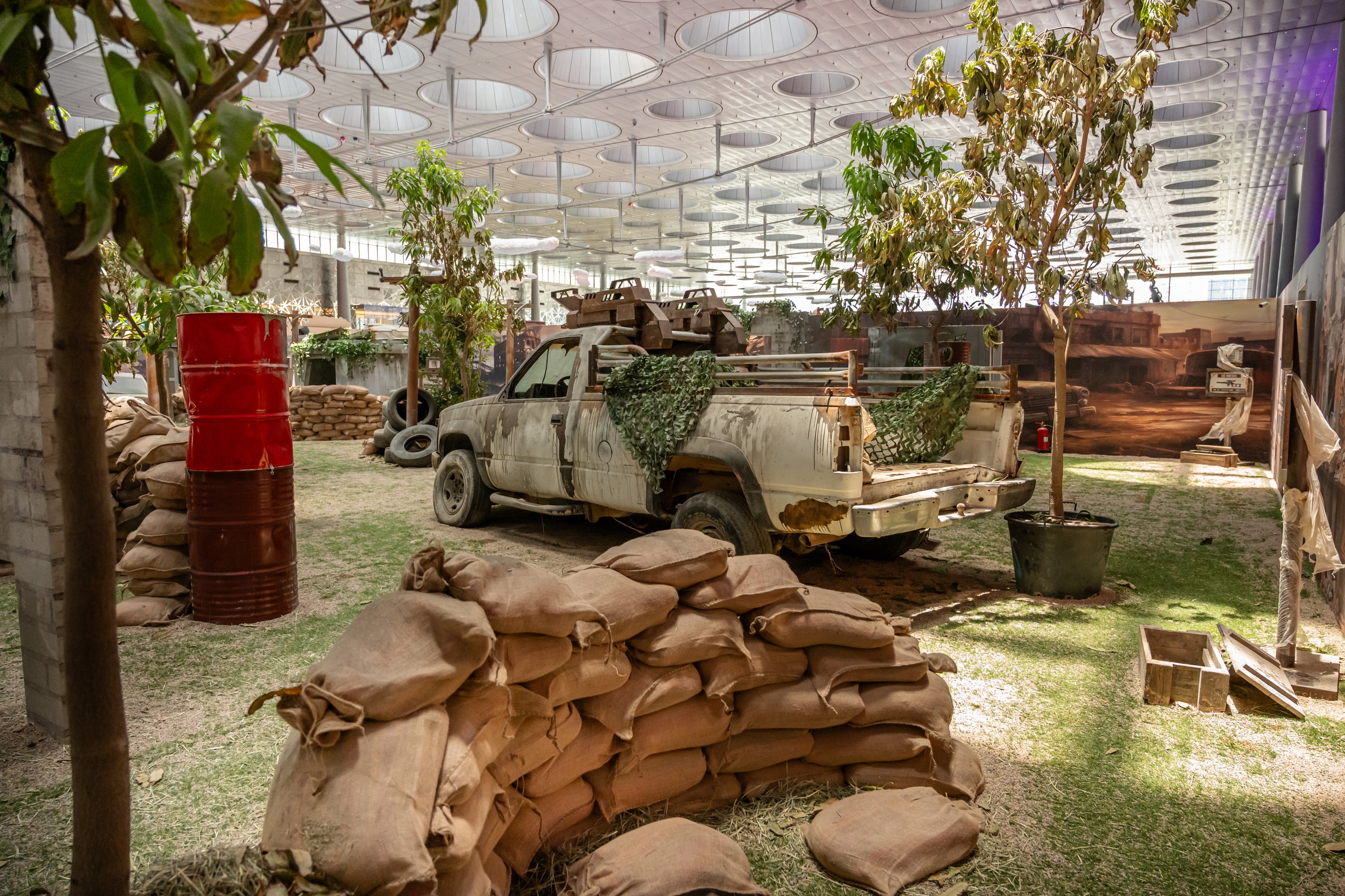Battleground set with ruined walls, sandbags and vehicles