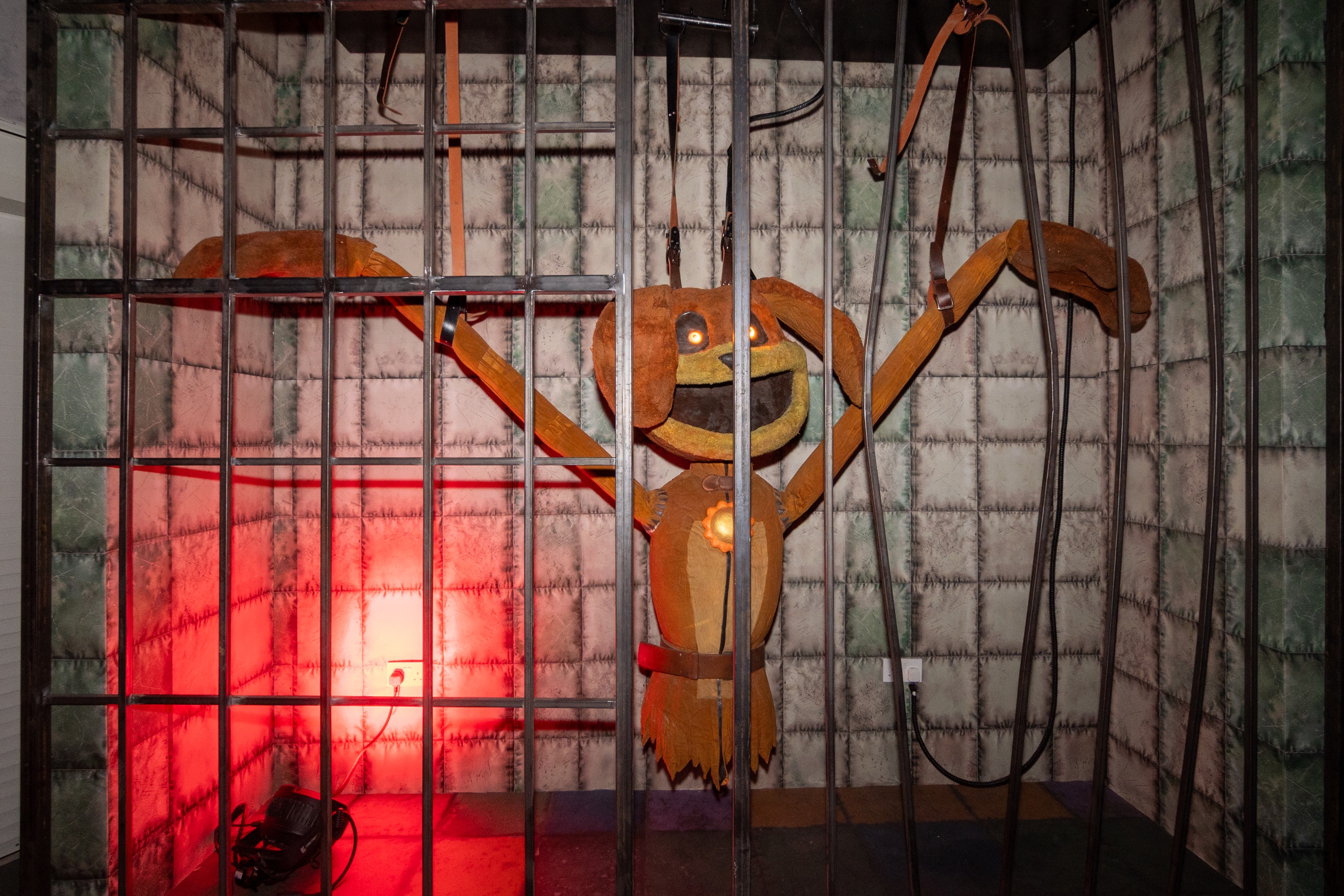Caged creature scene lit in red