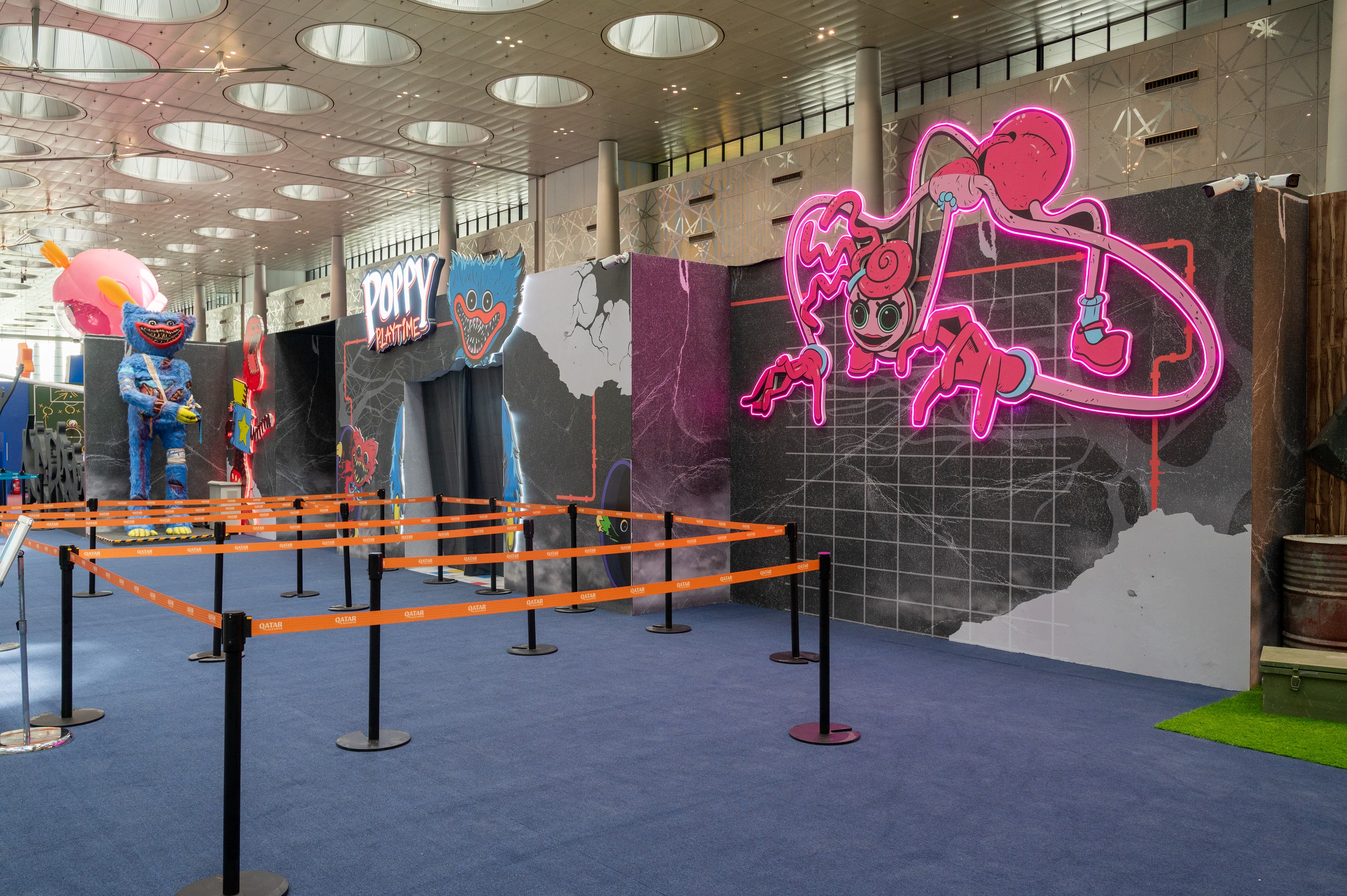Poppy Playtime attraction facade with pink neon character art