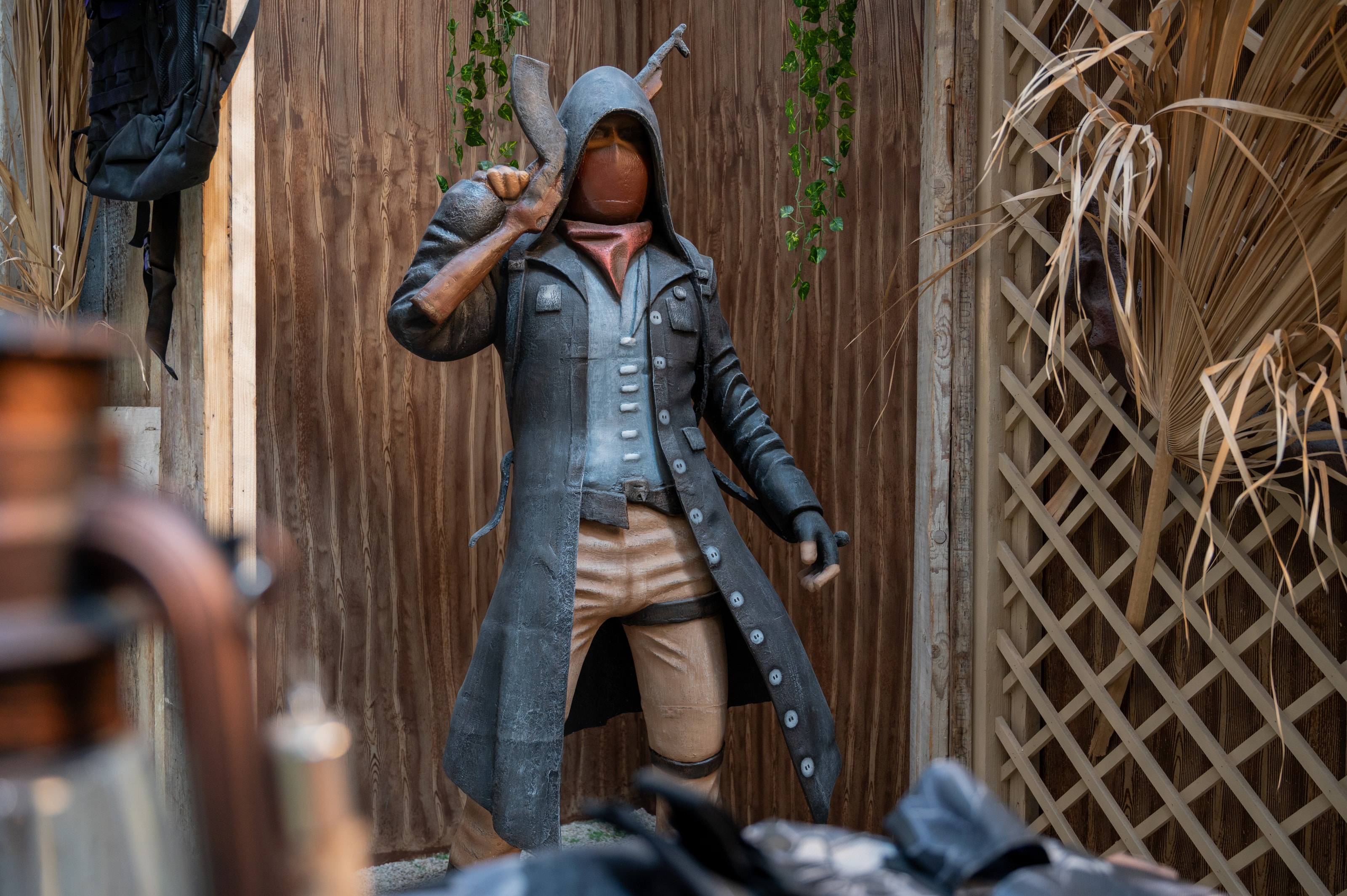 Hooded PUBG character figure among lattice walls