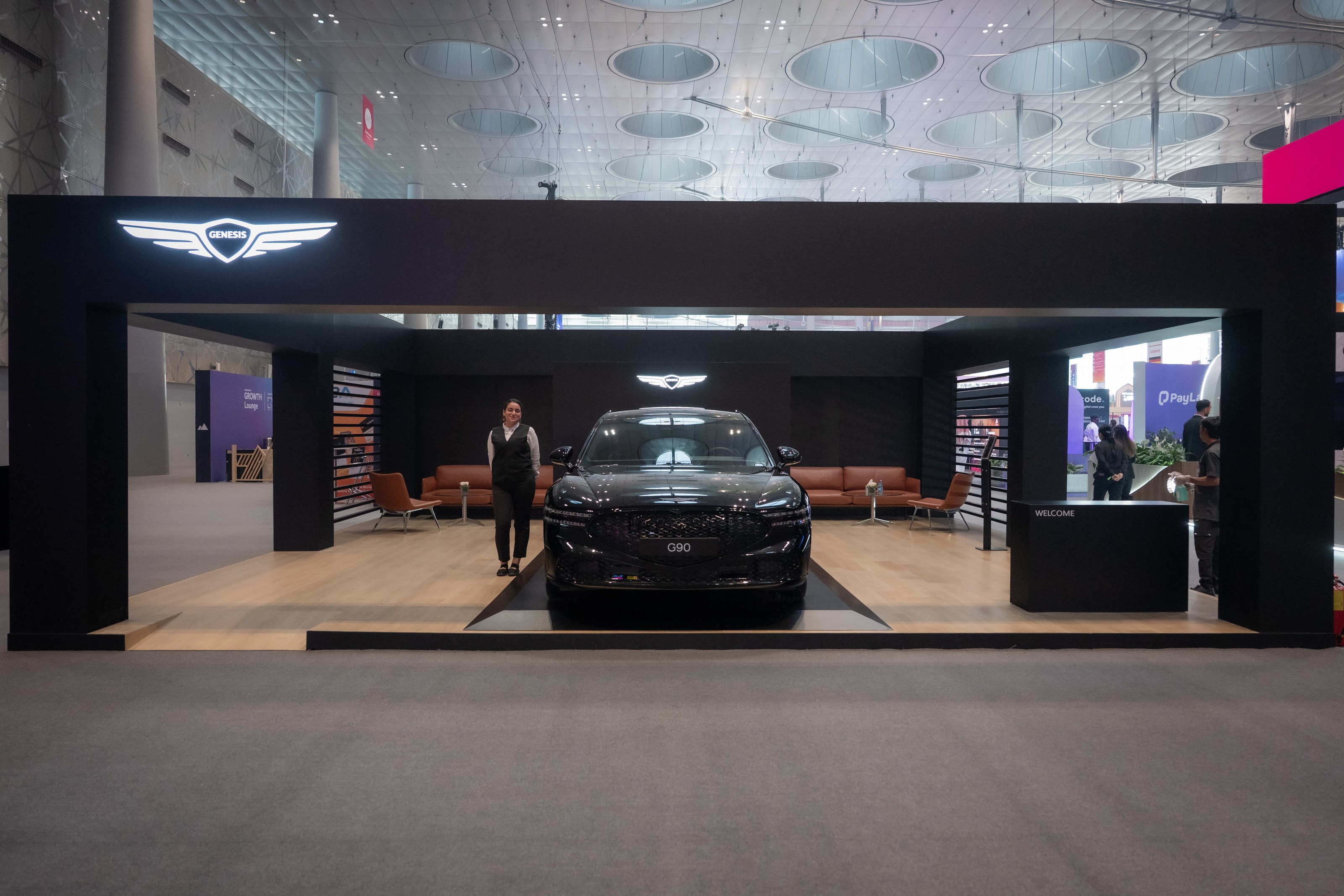 Genesis pavilion with a host beside the G90