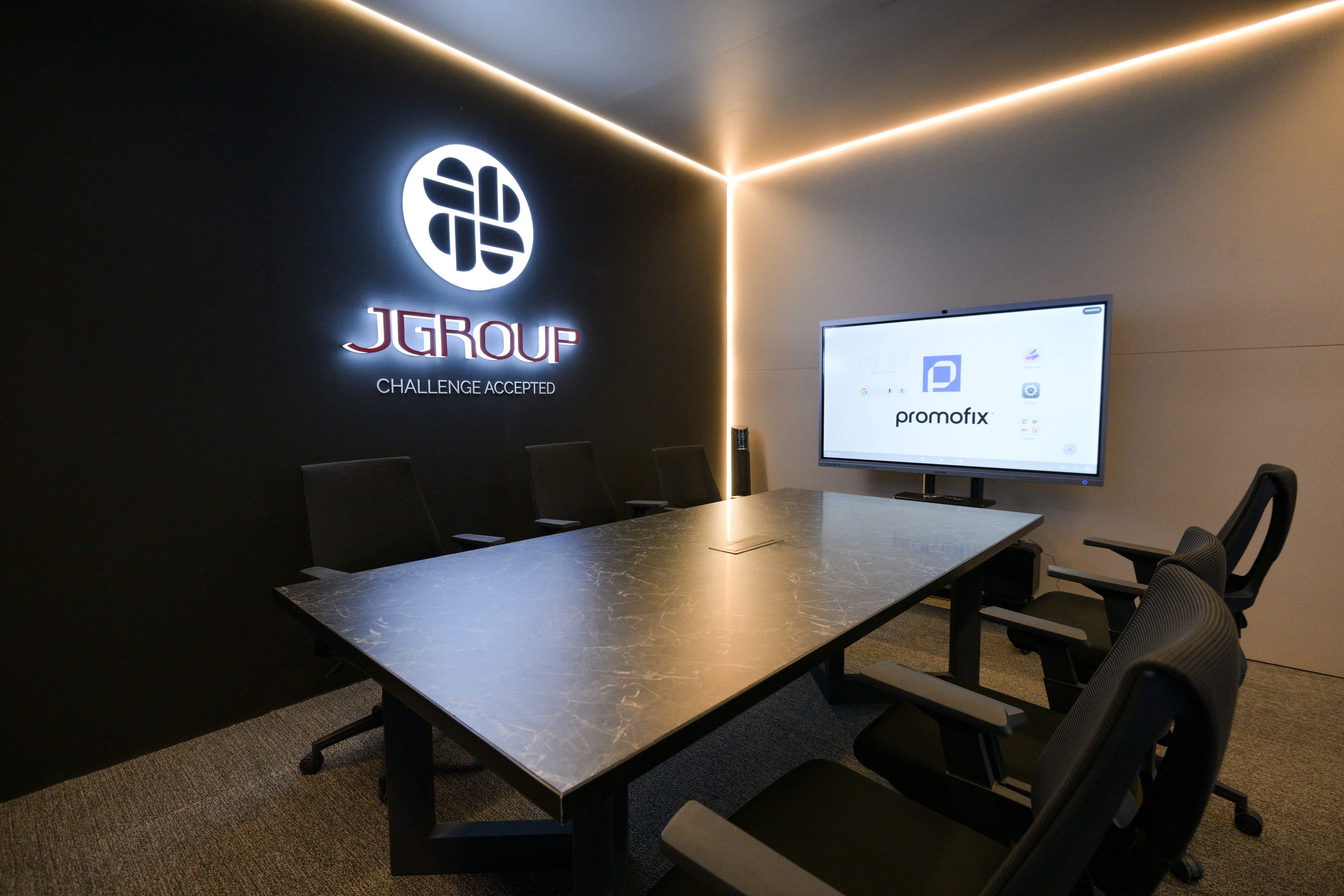 Black boardroom with an illuminated J Group logo