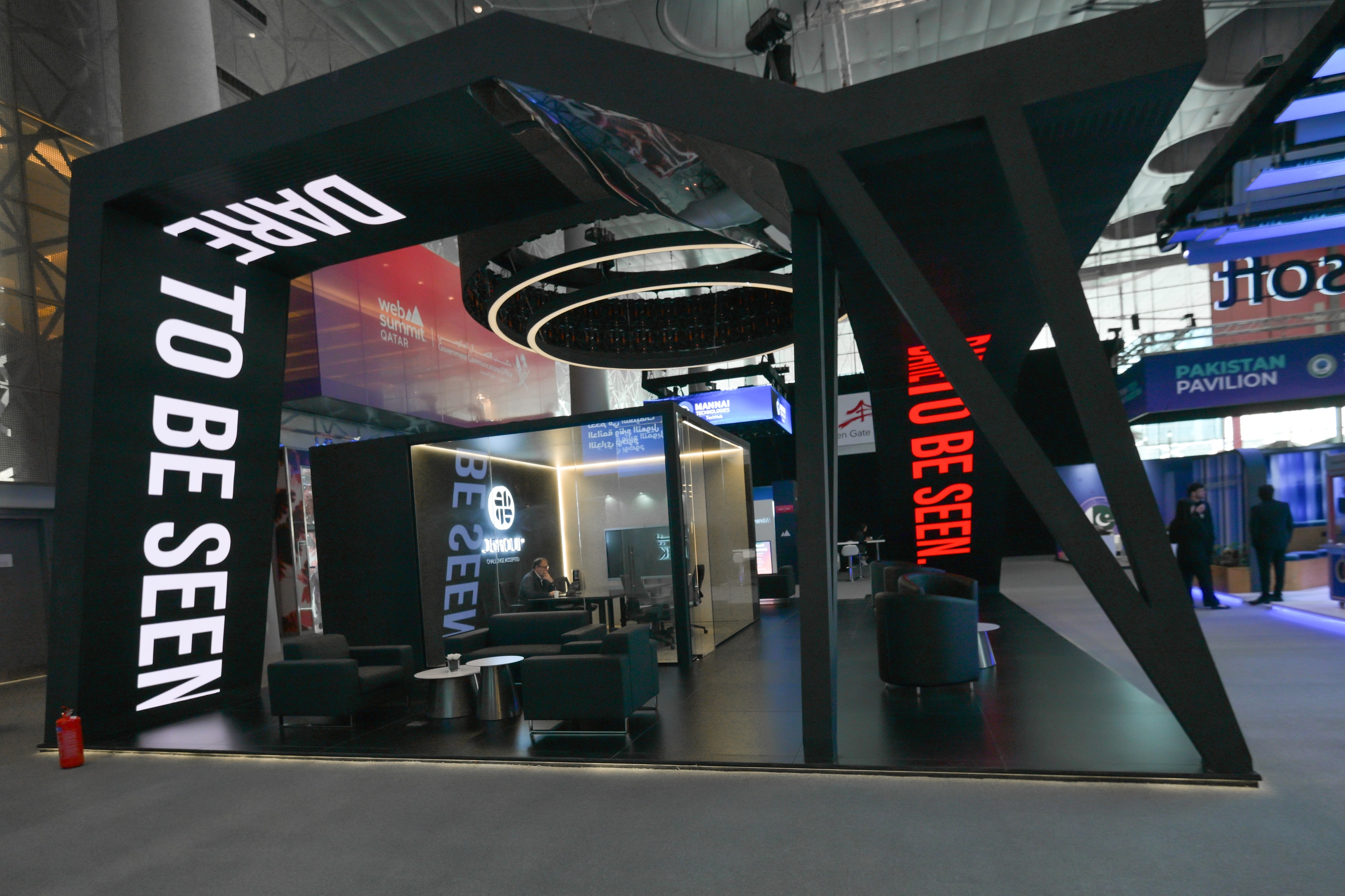 J Group stand with an angled “Dare to be seen” light-box blade